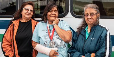 Three women passengers in front of Tribal transit vehicle