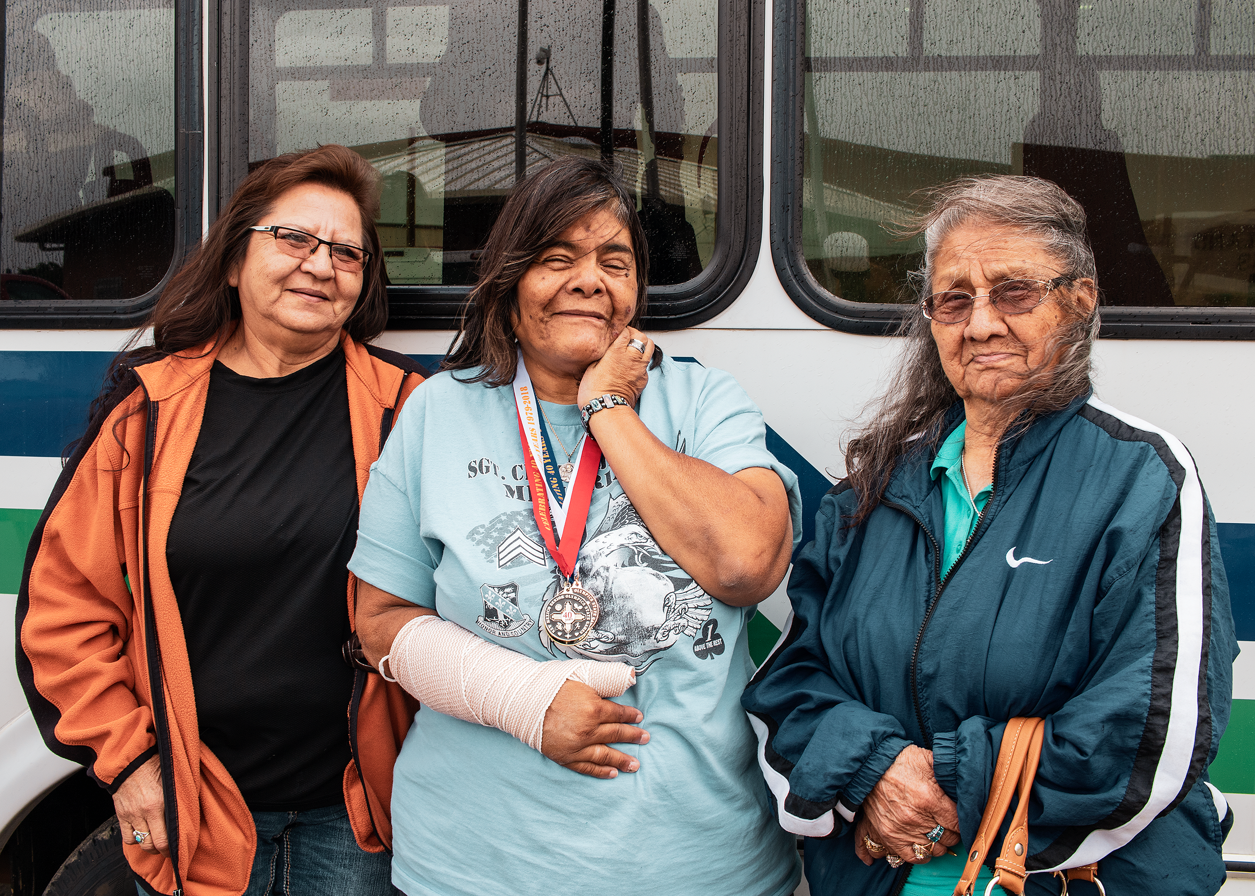 Three women passengers in front of Tribal transit vehicle