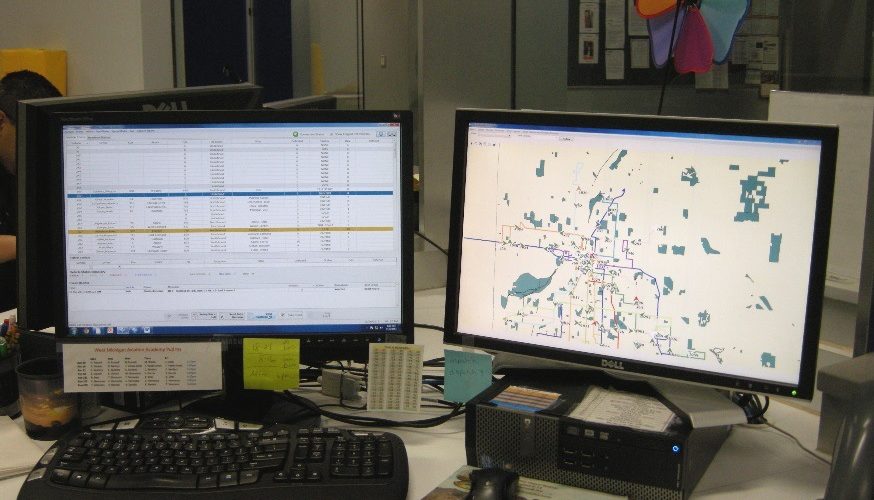 Two computer monitors showing a map and database
