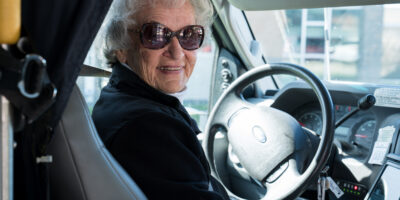 older woman with sunglasses in driver seat