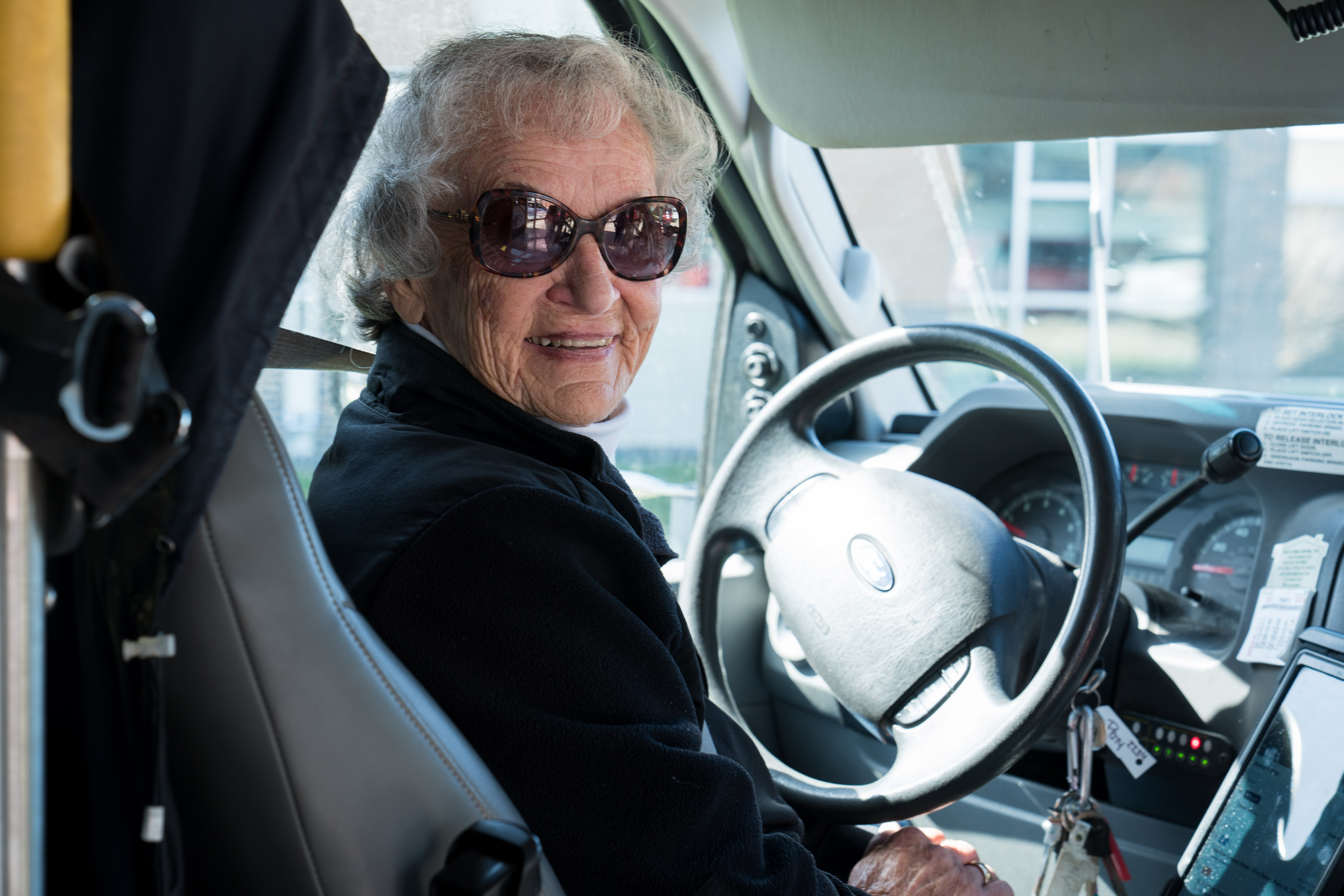 older woman with sunglasses in driver seat