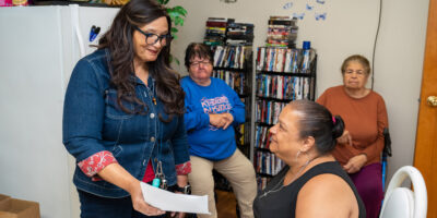 Woman showing a form to three individuals in office