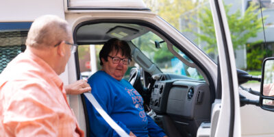DSC05208 Driver assisting woman with seatbelt in front seat of van