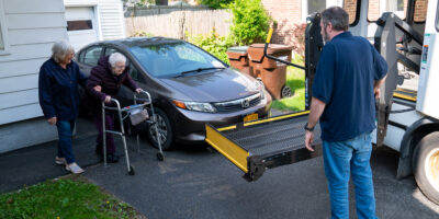 DSC06226 older woman walks with her walker towards vehicle with ramp lowering