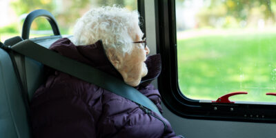 WomanGazingOutWindow Older woman gazing out bus window