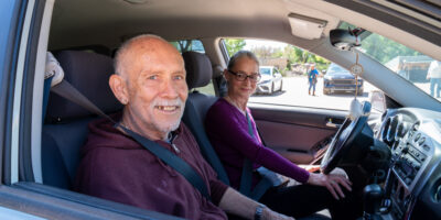 volunteer driver with older adult in front seat