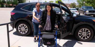 DSC09020 Volunteer driver assists woman with walker