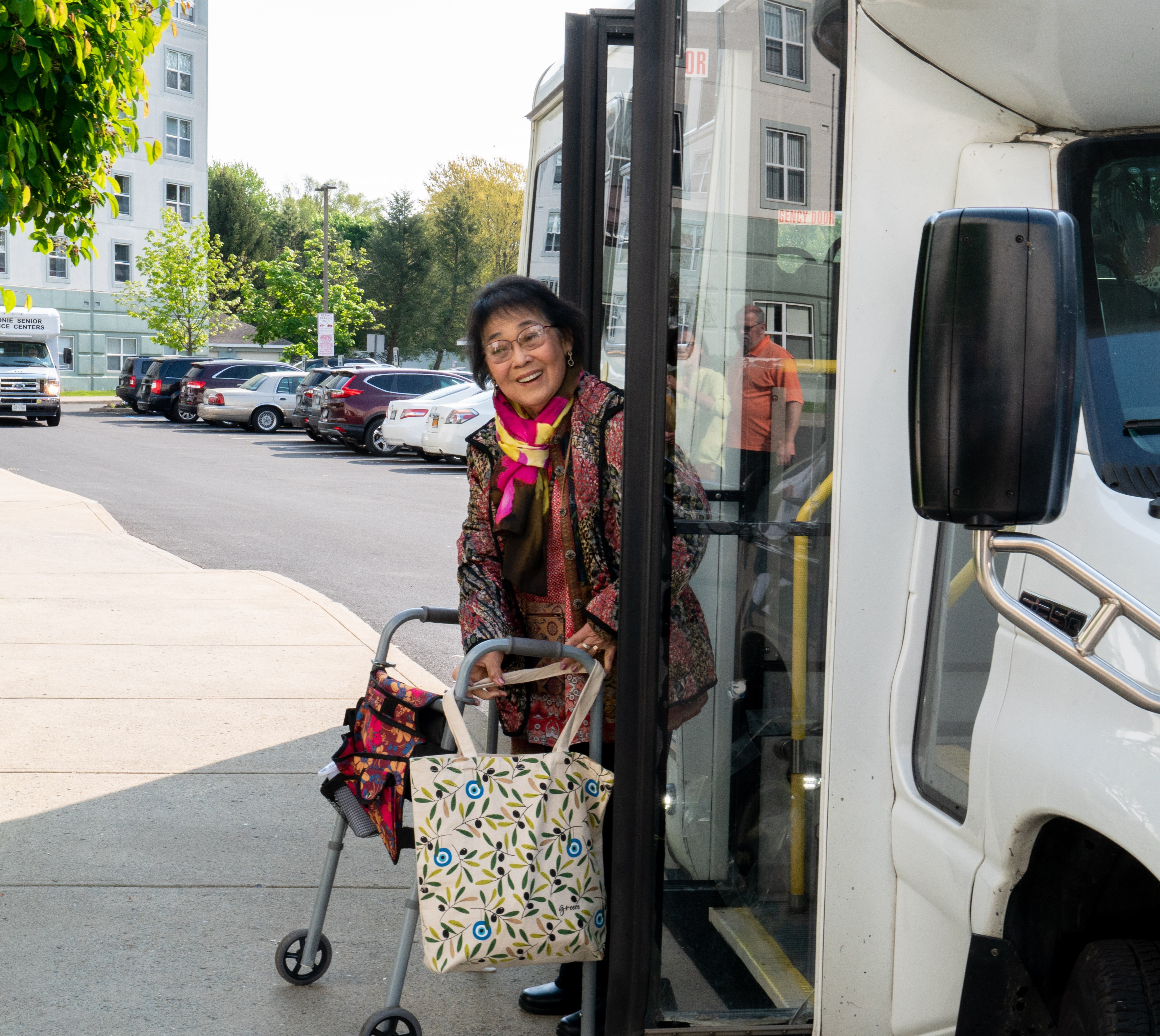 Woman with walker smiles when exiting bus
