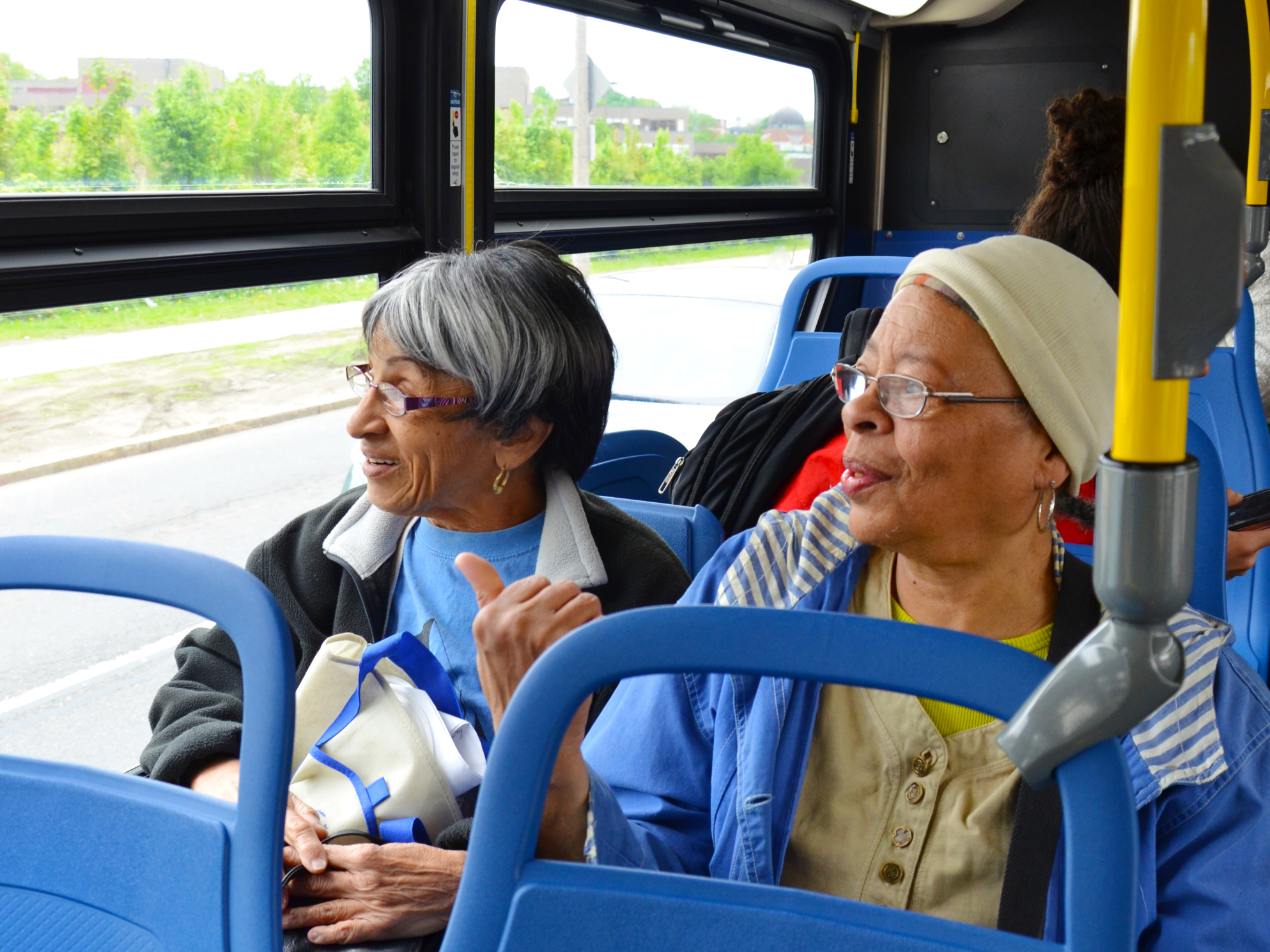 Photo of two older women sitting on a bus looking out the window. Credit: City of Boston