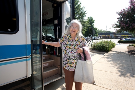 Older lady standing by bus