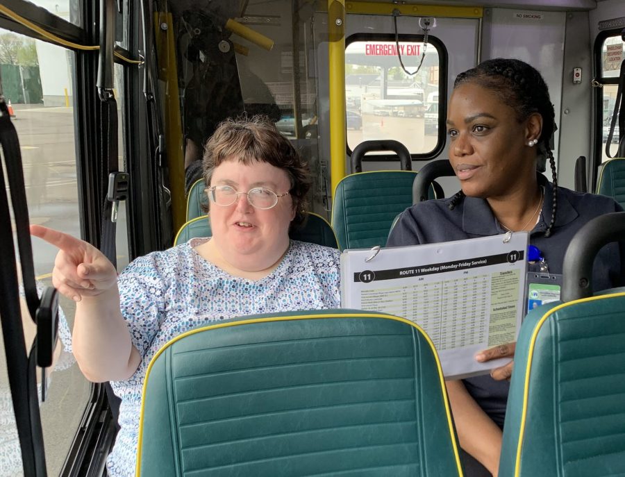 Travel trainer with individual with disability on bus
