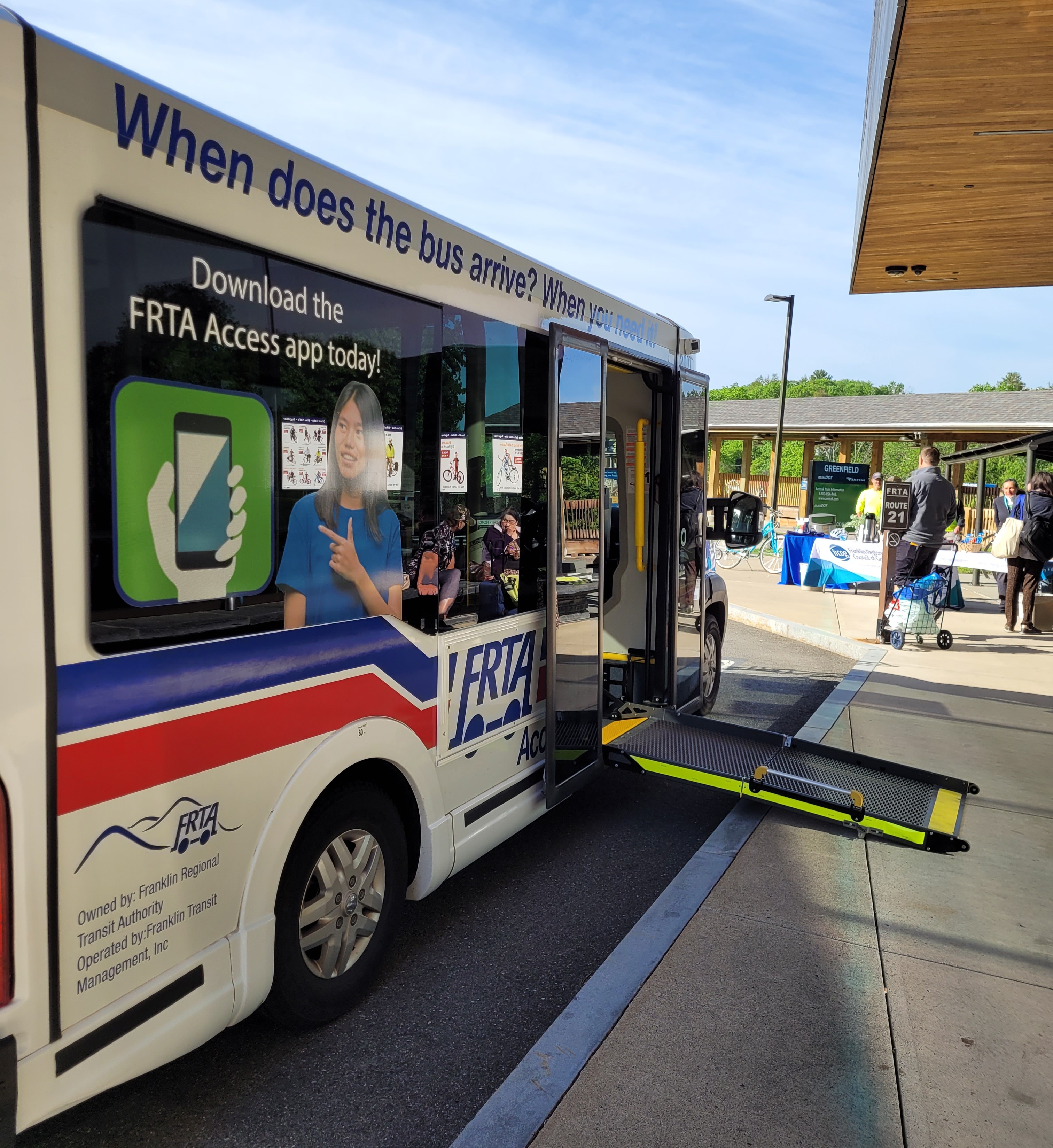 Colorful bus with wheelchair ramp deployed.