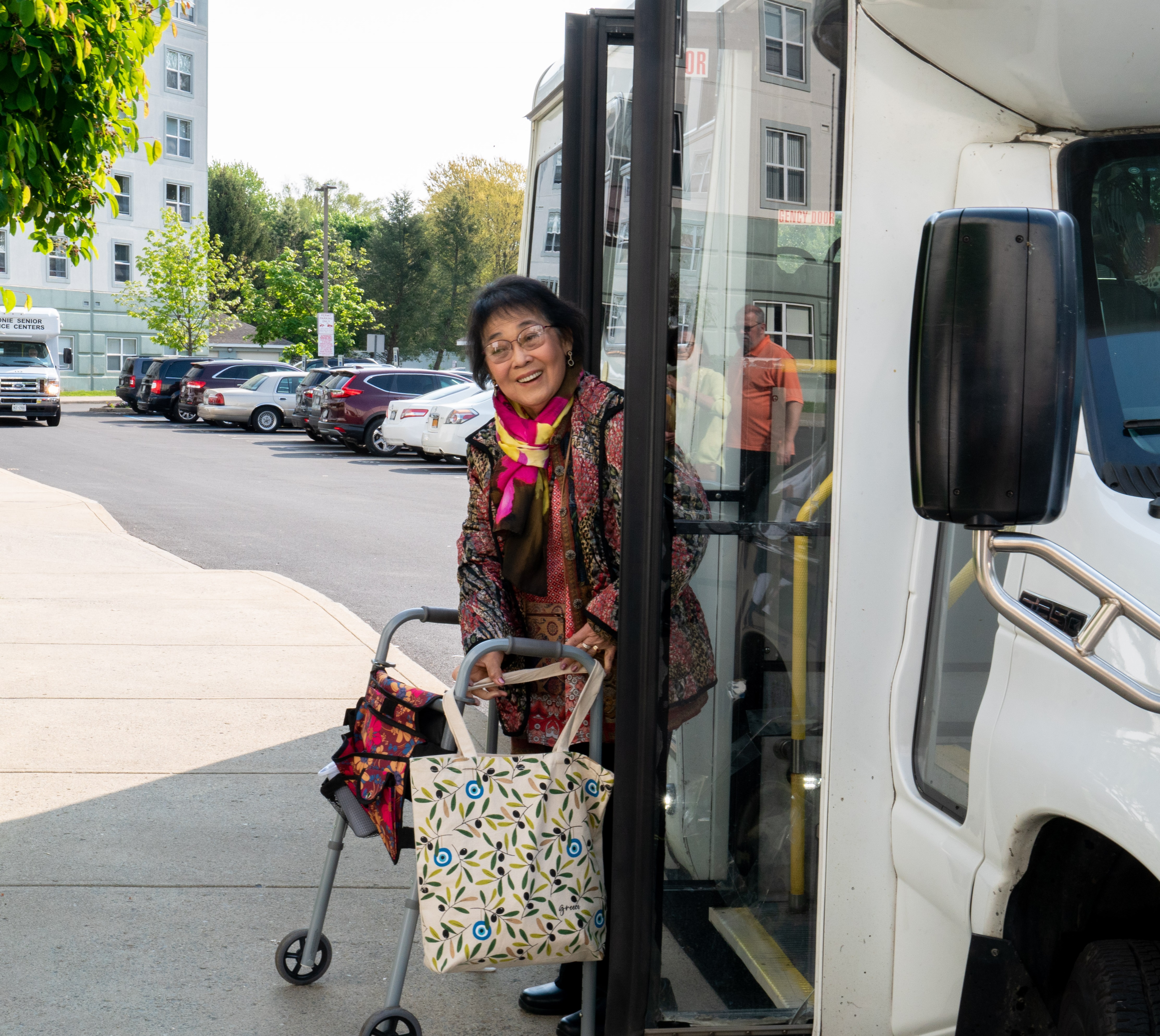 happy woman with walker exits bus